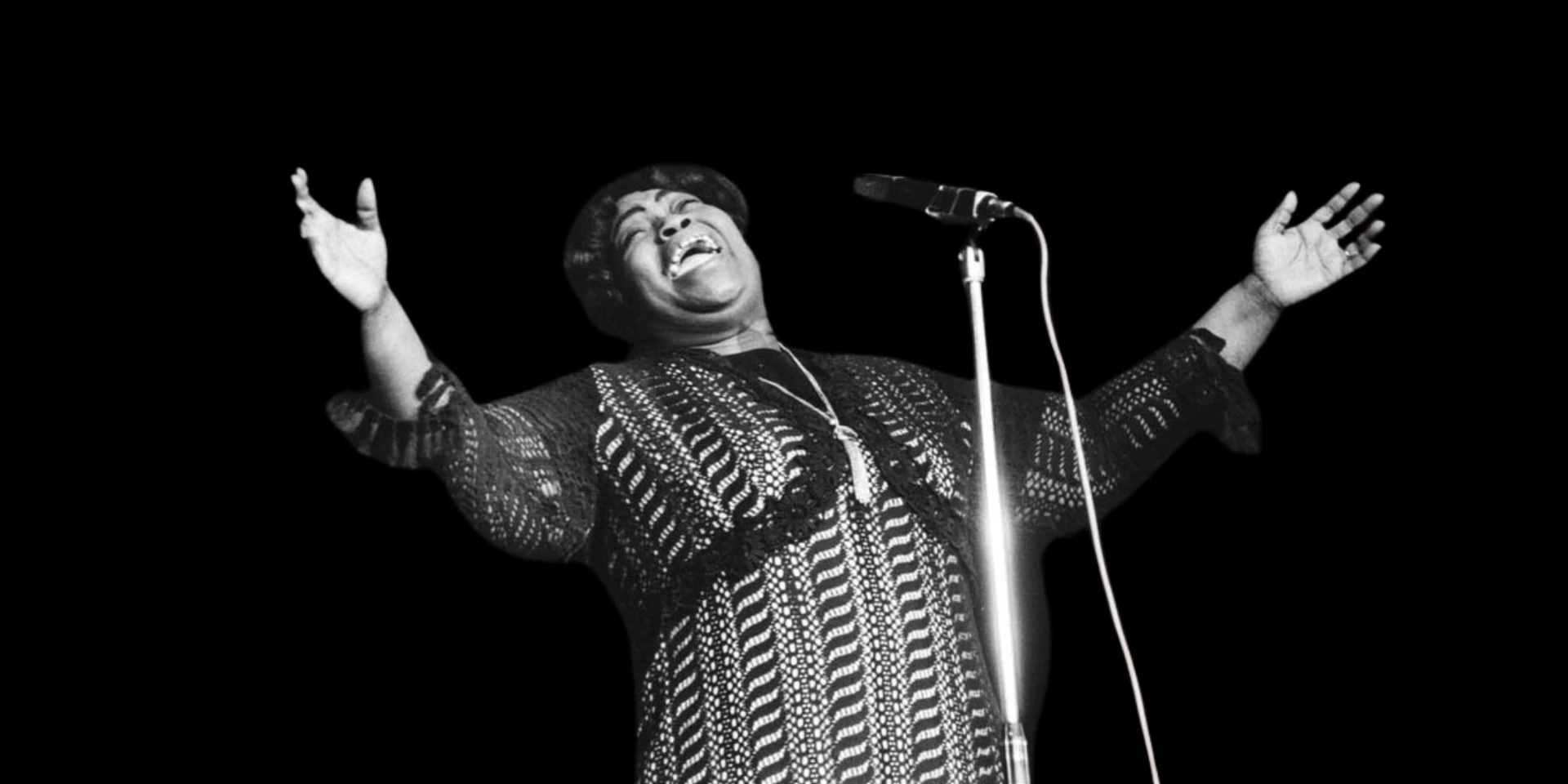 Marion Williams singing with arms outstretched at a microphone